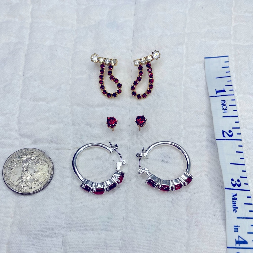1 pair silver/red hoops. 1 pair gold studs w/red gems. 1 Set of Red/white stones